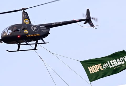 A helicopter flying a banner over the course